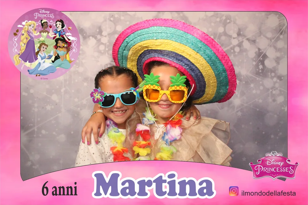 Due bambine con sombrero e occhiali ananas nella cornice rosa di un sesto compleanno
