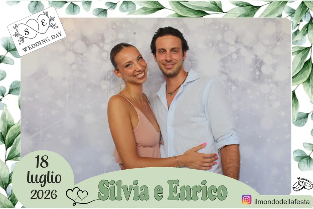 Una coppia di invitati nella cornice a foglie di eucalipto del matrimonio del 18 luglio